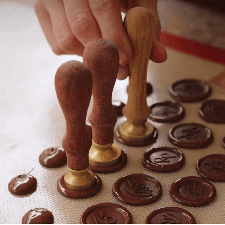 Custom chocolate stamp pressing a logo into melted chocolate in Umm Al Quwain